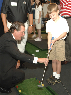 picture Golf great Phil Michelson teaching a young golfer