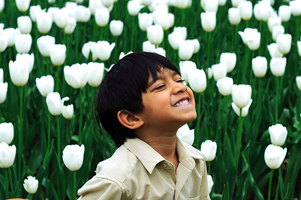 A smiling child in a field of flowers