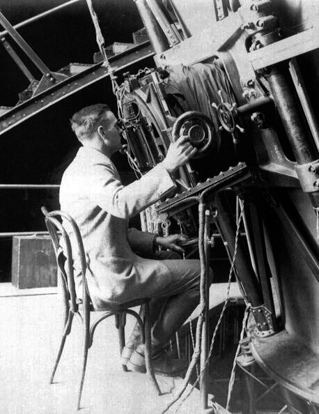 Edwin Hubble looking through a large telescope