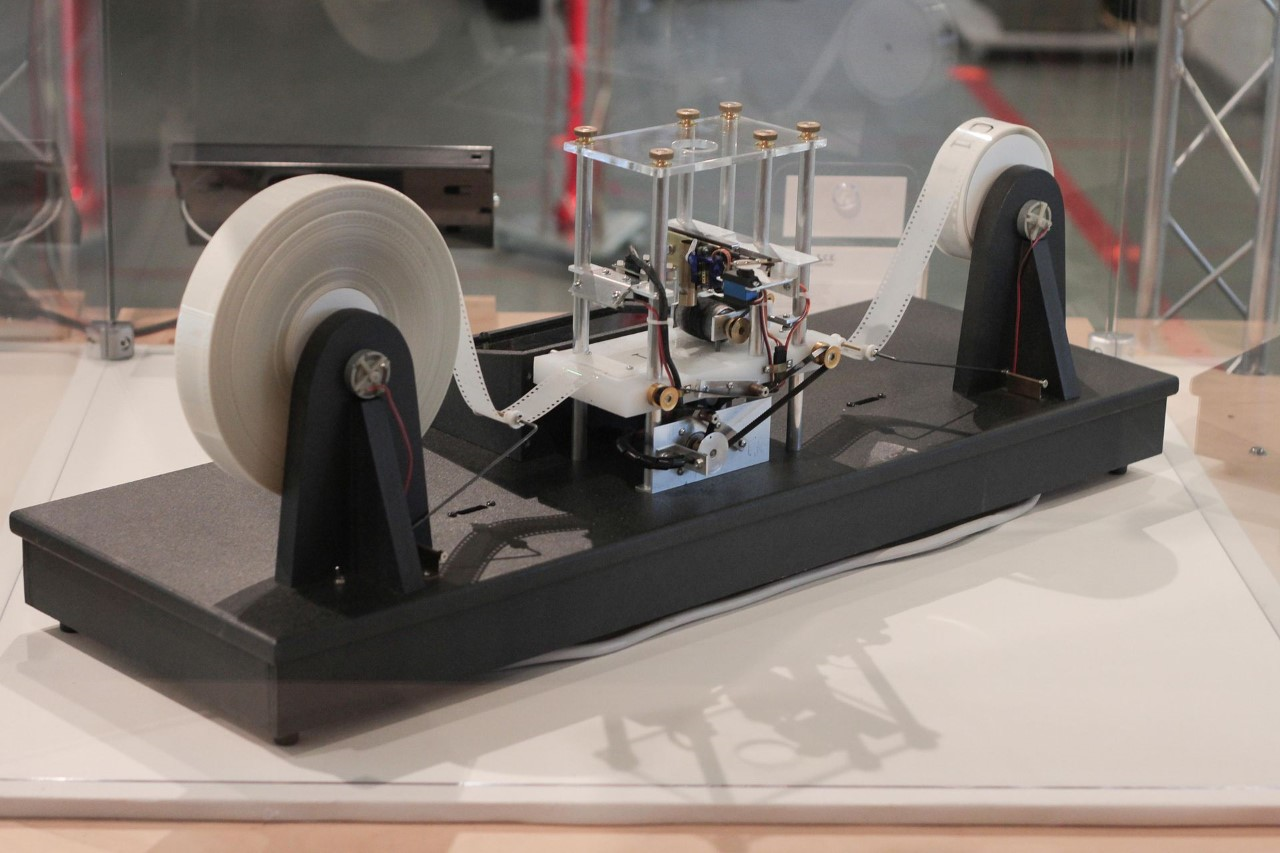 A physical Turing machine which is used in the precise definition of complexity that is discussed in this episode. A true Turing machine would have infinite tape on both sides.