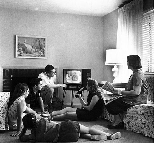 black and white image of a family watching television