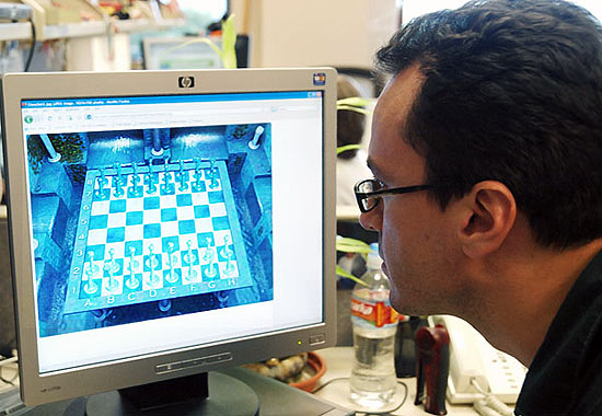 photograph of a man playing checkers on the computer