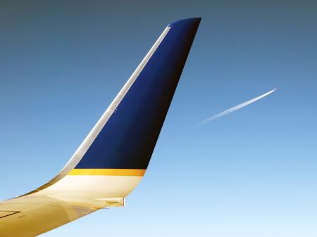 Winglet on a Continental jet with another airplane's contrails in the distance